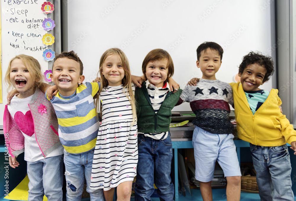 一群不同的幼儿园学生站在教室里