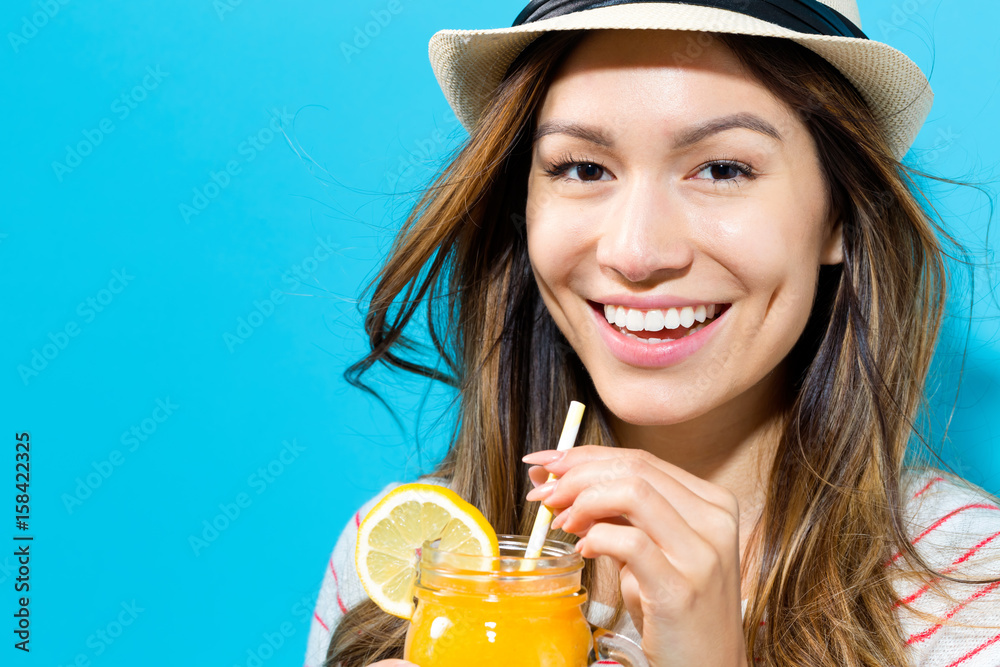 Happy young woman drinking smoothie