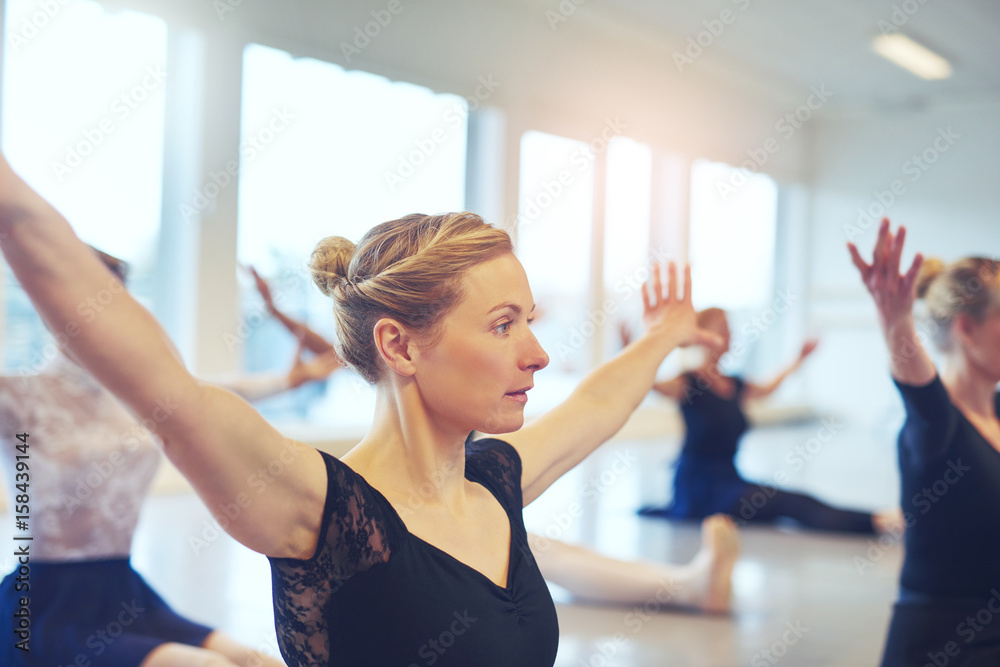 Women with hands apart doing gymnastics in ballet class