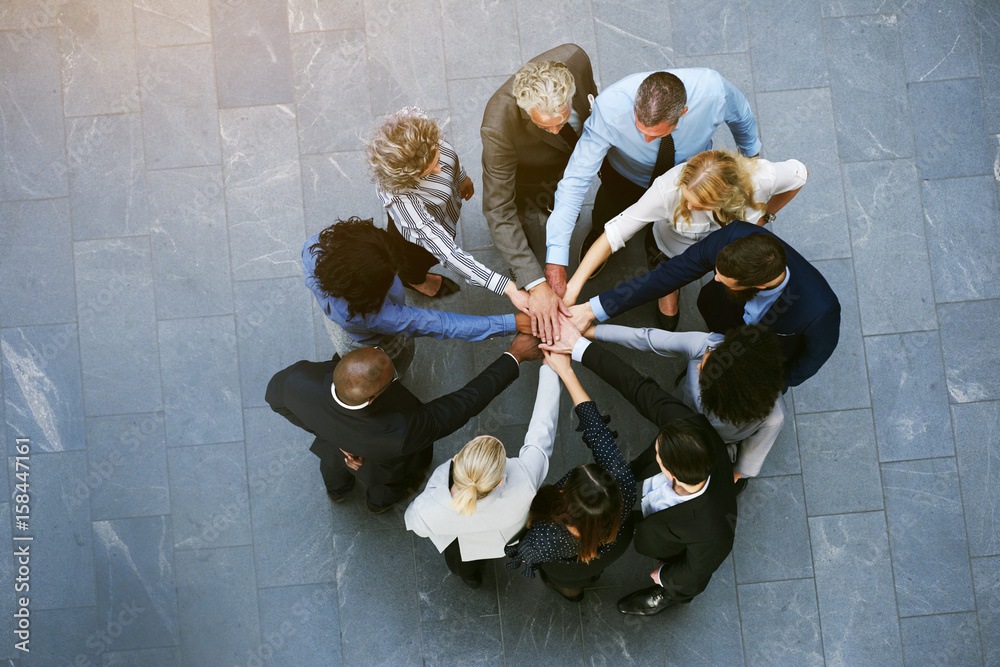 Multiracial office workers having teambuilding with hands stacked