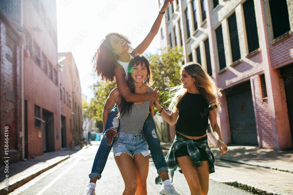 Three young woman having fun on city street