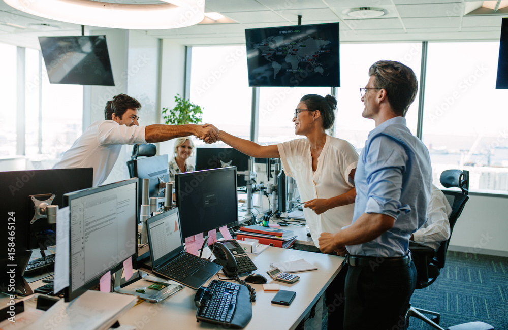 Business colleagues shaking hands in office