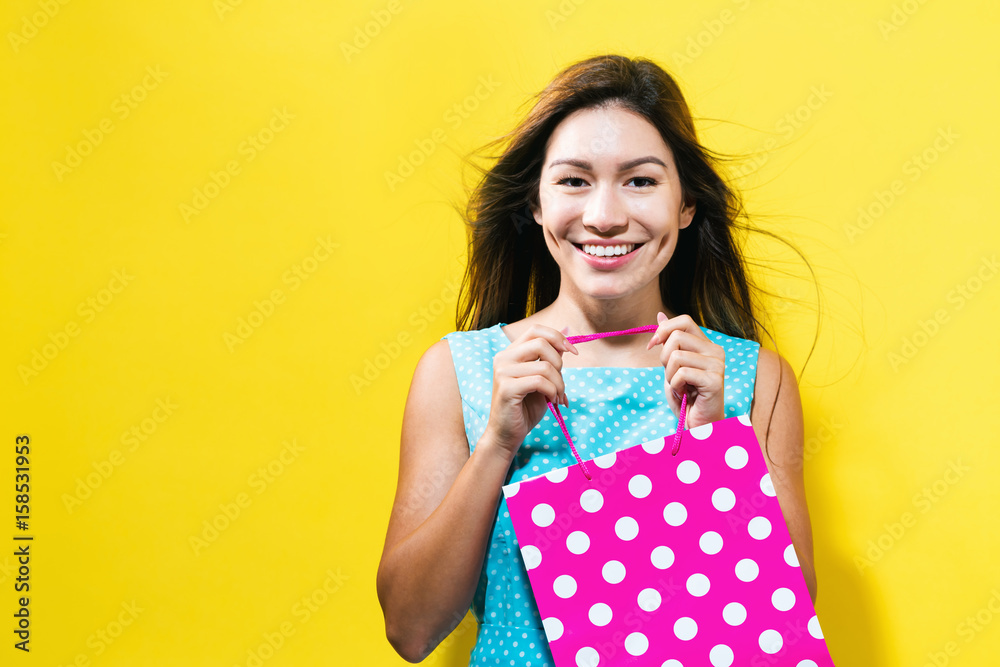  Happy young woman holding a shopping bag