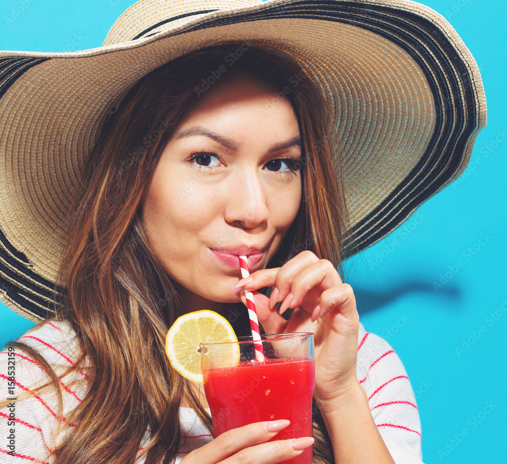 Happy young woman drinking smoothie