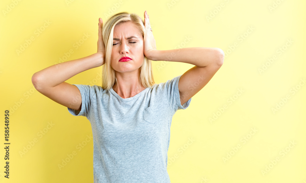 Young woman blocking her ears