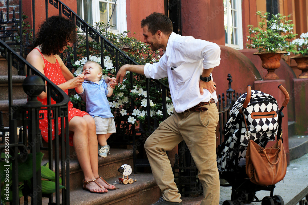 Young happy family on the street near house