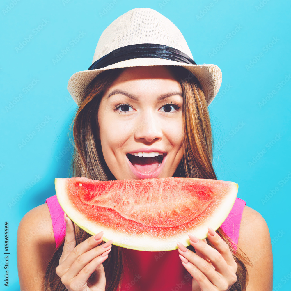 Happy young woman holding watermelon