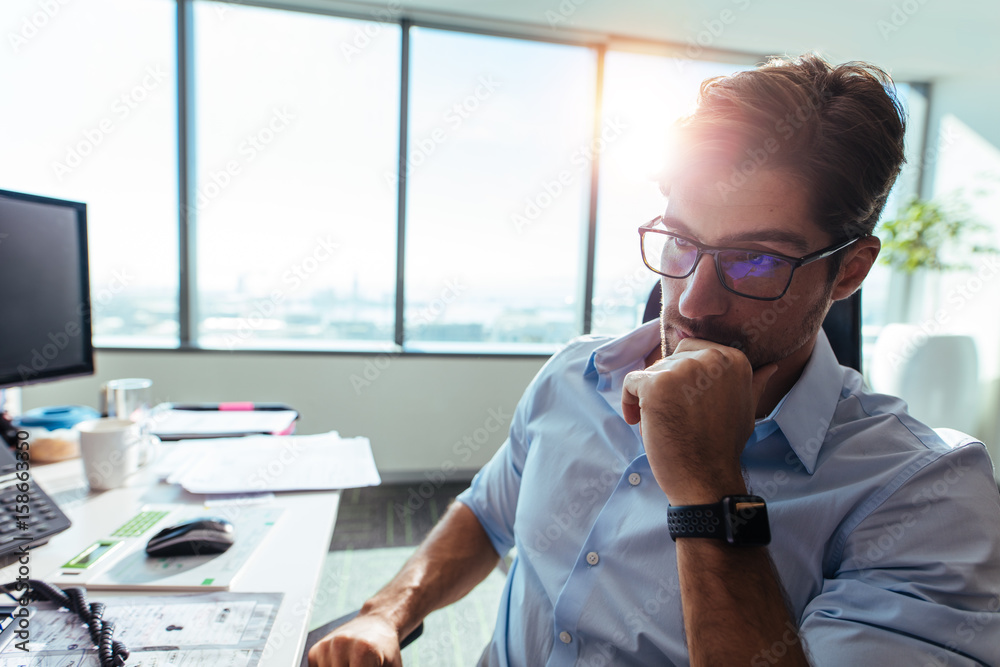 Businessman sitting at his desk in office.