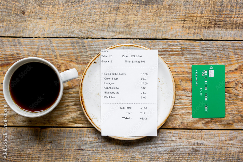 restaurant bill, card and coffee on wooden table background top view