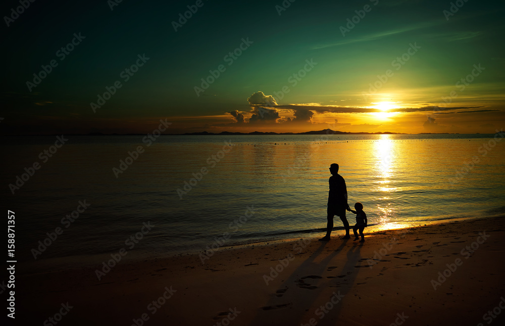 Father and his child walking on sunset beach , silhouette shot and tone image .