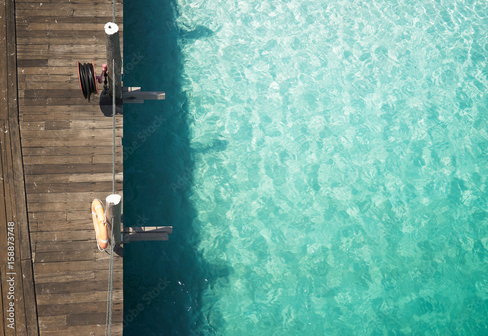 Wooden jetty with crystal clear and turquoise sea water of the tropical sea . Aerial top view .Rawa 