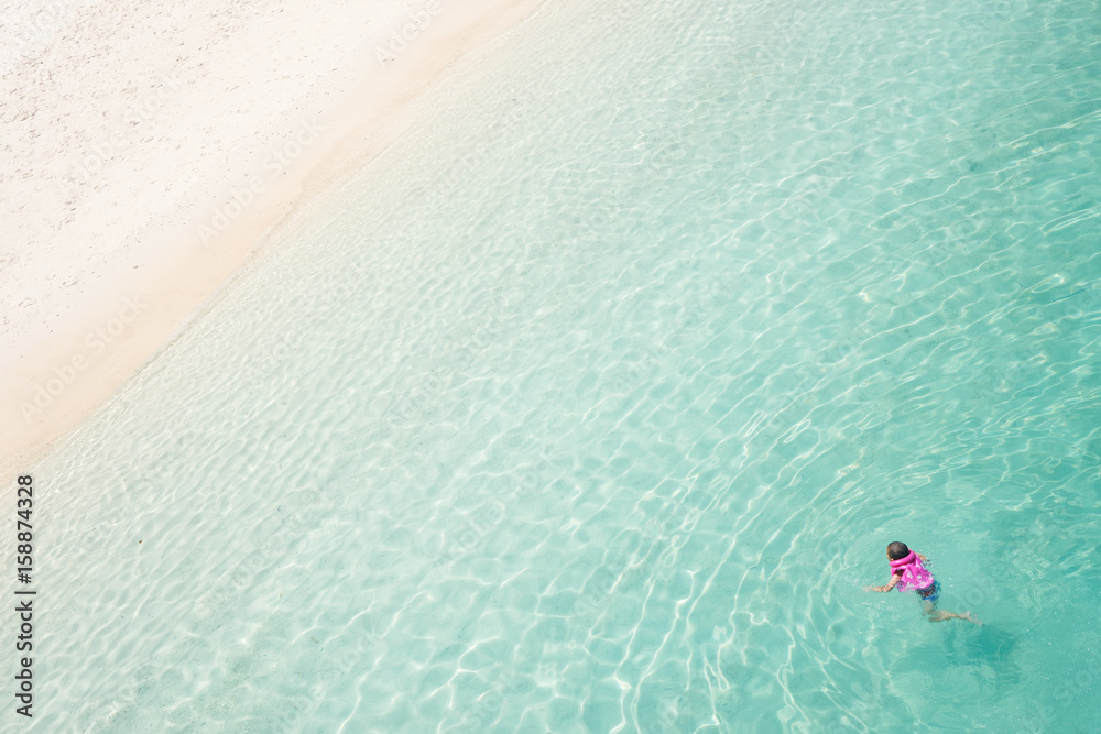 Kid snorkling and relaxing crystal clear and turquoise sea water of the tropical sea .