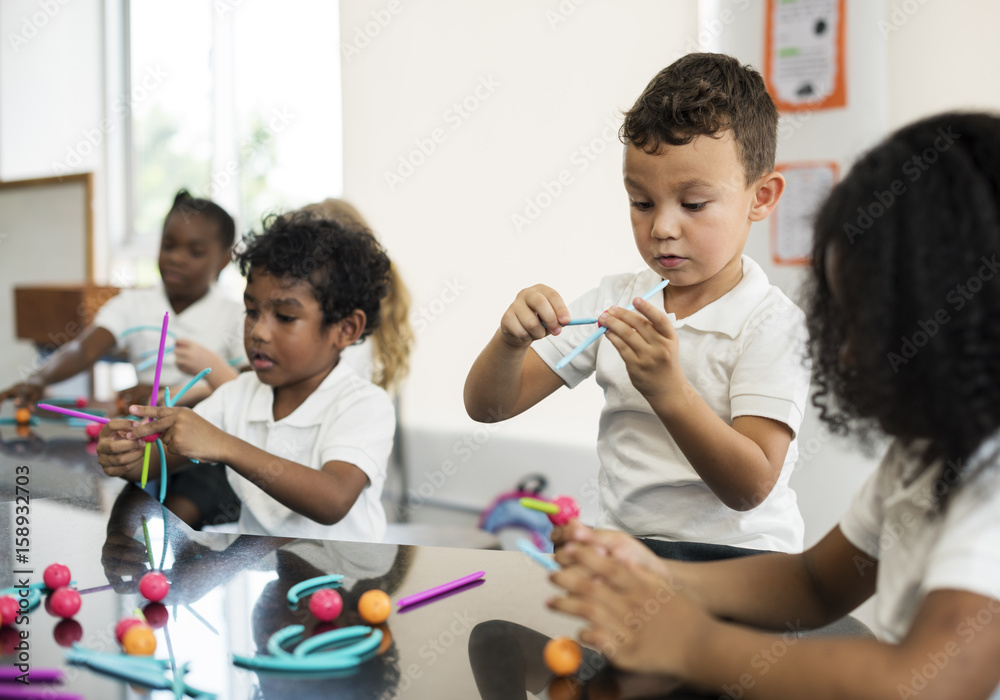 Kindergarten students holding learning structures from toys