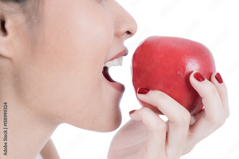 Close-up Asian portrait of young woman eating red apple. Healthy food concept. Skin care and beauty.