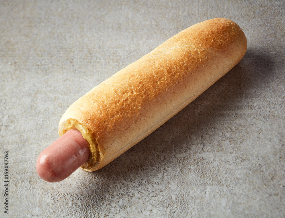 Hotdog with mustard on grey table