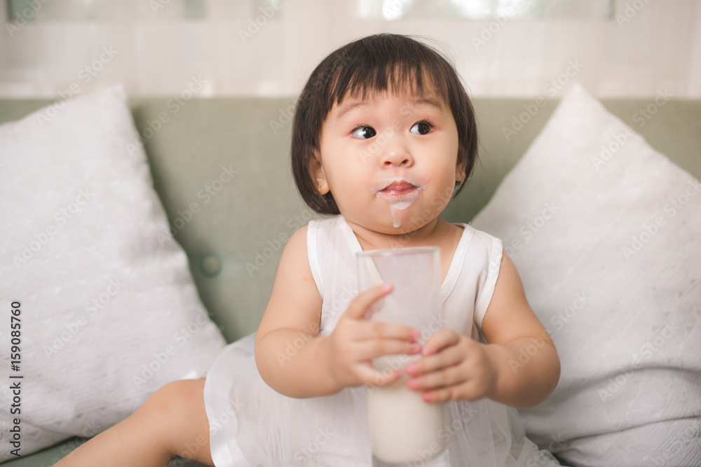 可爱的女婴在家留着牛奶胡子喝牛奶