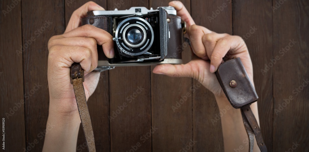 Composite image of cropped image of hands holding camera