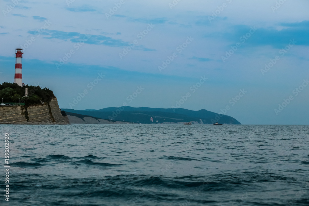 海上海岸的灯塔。平静的蓝色大海和地平线上的灯塔。海上地平线