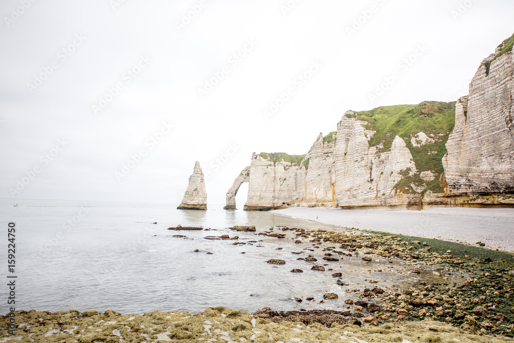 Landscape view on rocky coastline near Etretat town during the cloudy weather