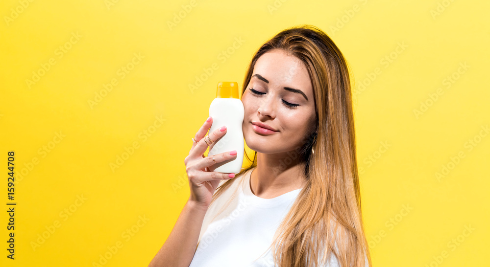 Young woman a bottle of sunblock