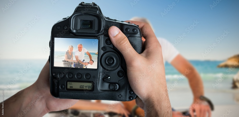 Composite image of cropped image of hands holding camera 