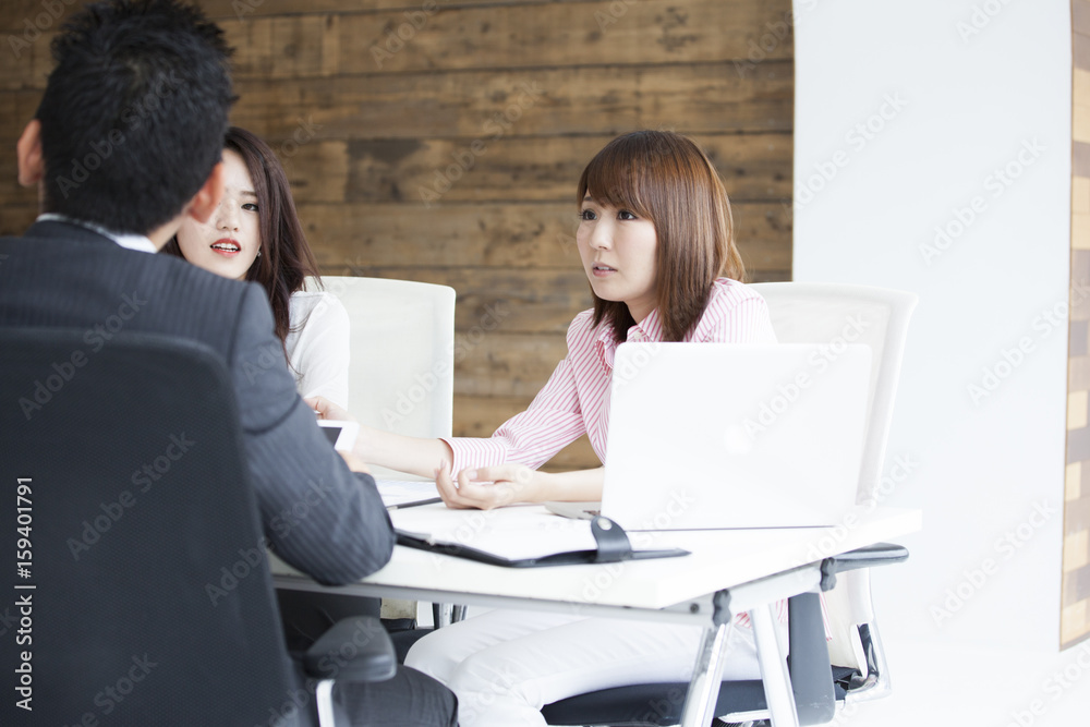 Three office workers are meeting at the office