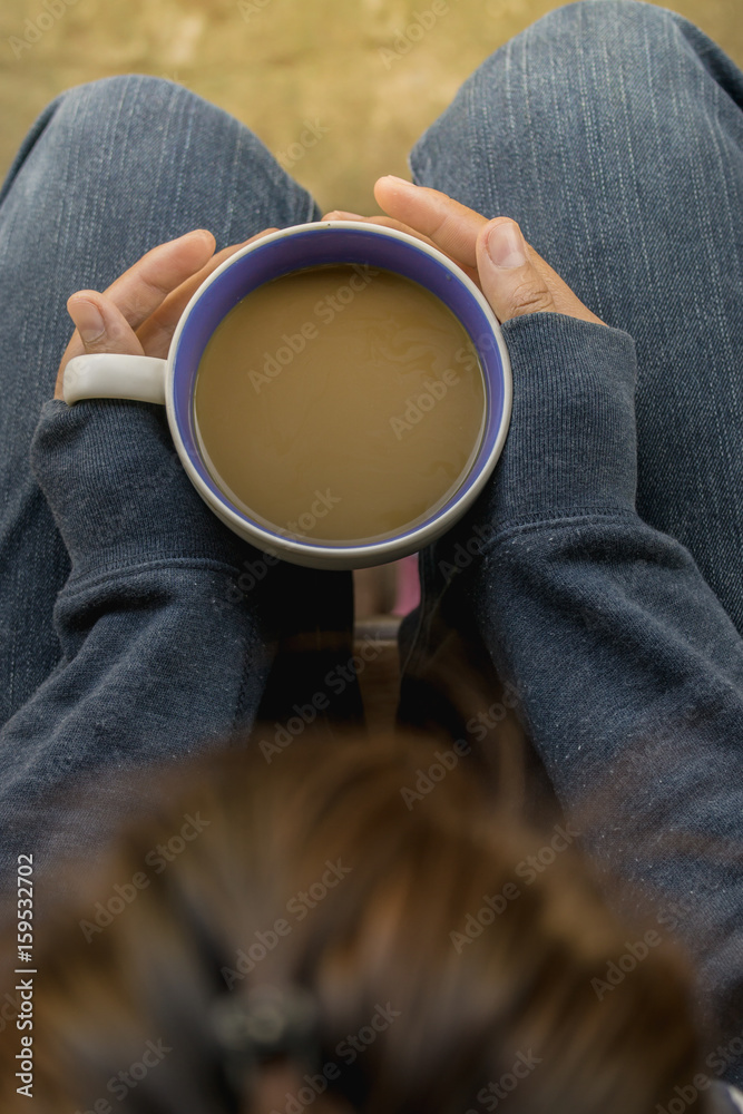 Female hands holding cups of coffee, top view.