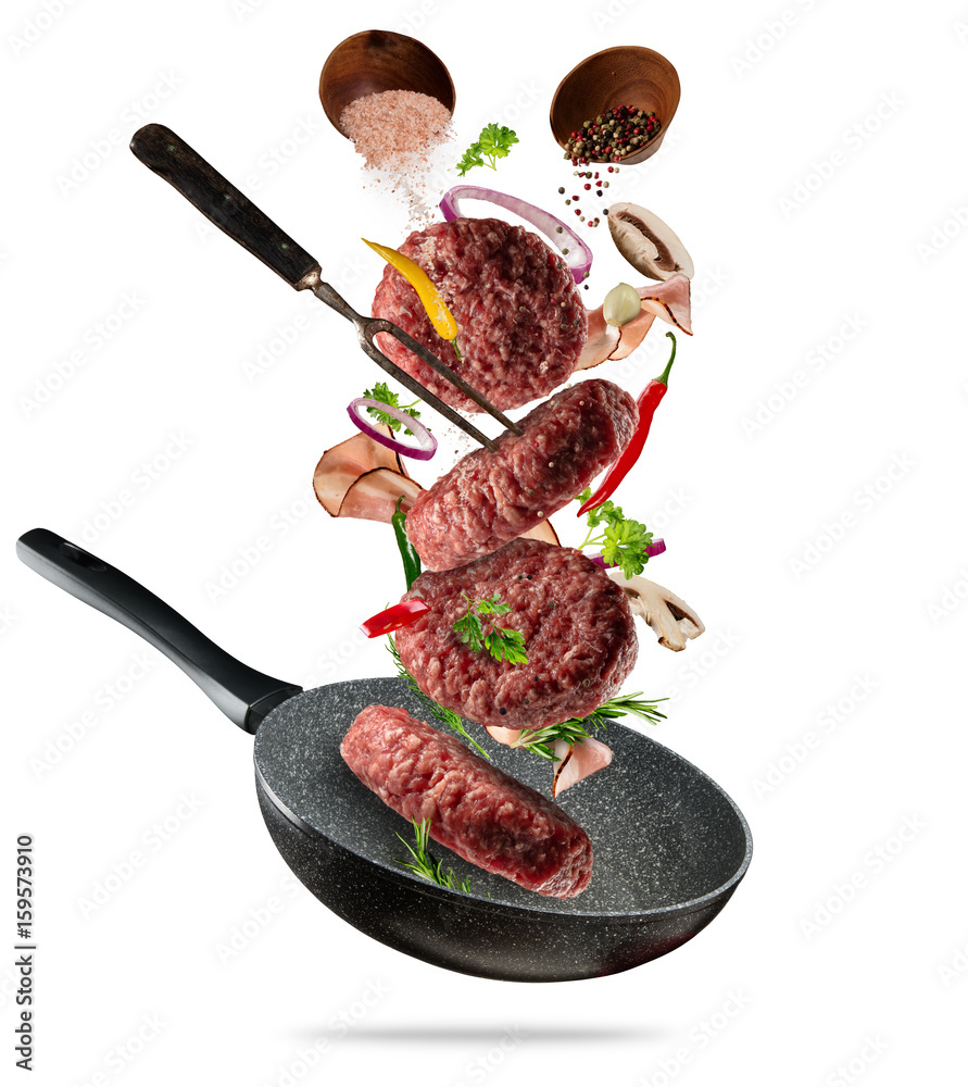 Flying raw milled hamburger meats pieces, with ingredients for cooking. Freeze motion of cooking sta