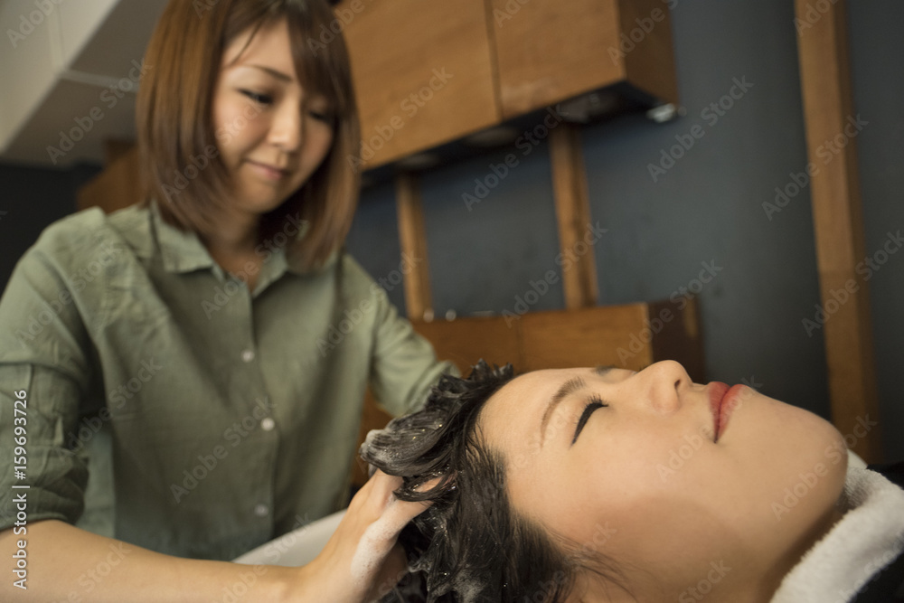 A woman has her hair washed in a hair salon