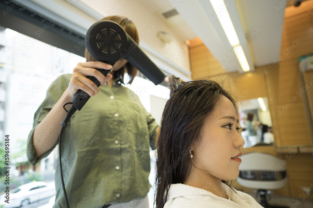 Hairdresser is drying womens hair