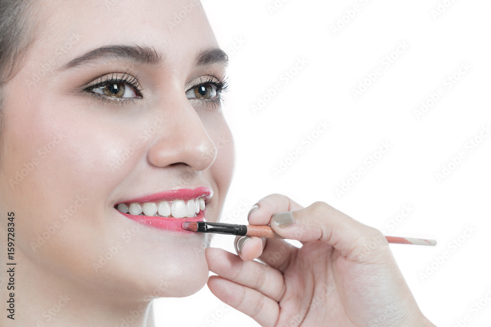 Professional makeup artist applies makeup for beautiful Asian young woman apply lip on mouth. studio