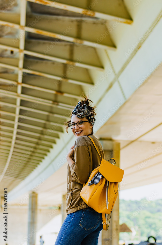 Fashion lifestyle portrait of young happy pretty woman smiling outside.