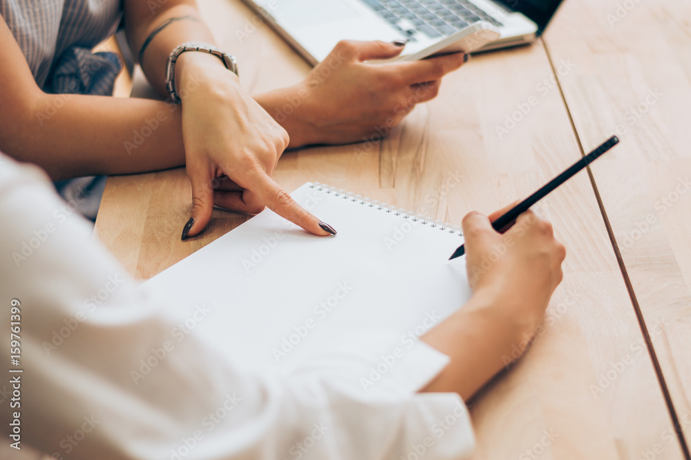 Businesswoman holding a pen and pointing at something while dealing with her colleague