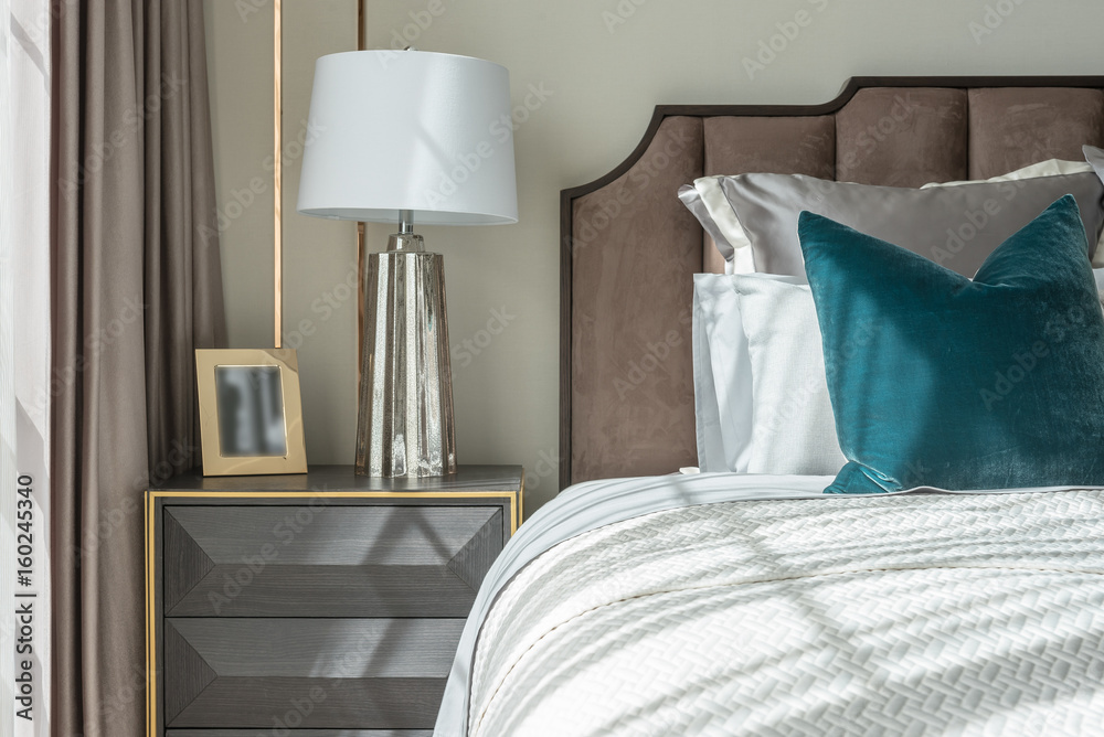 classic bedroom style with set of pillows and lamp on table side