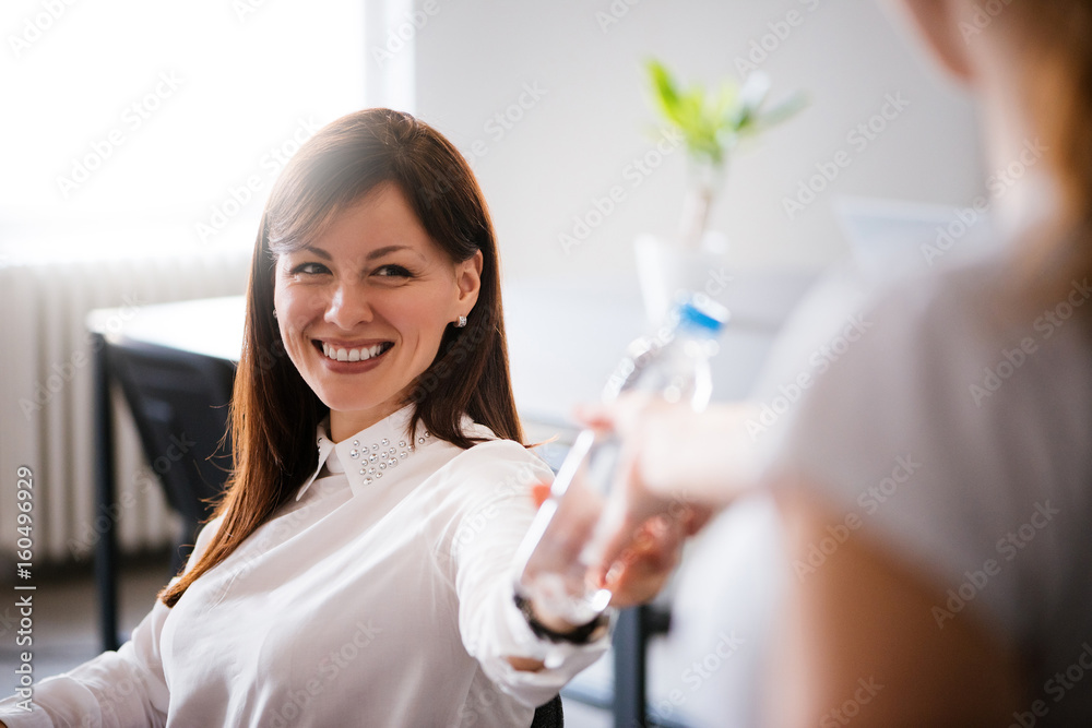 女人从同事那里拿水瓶