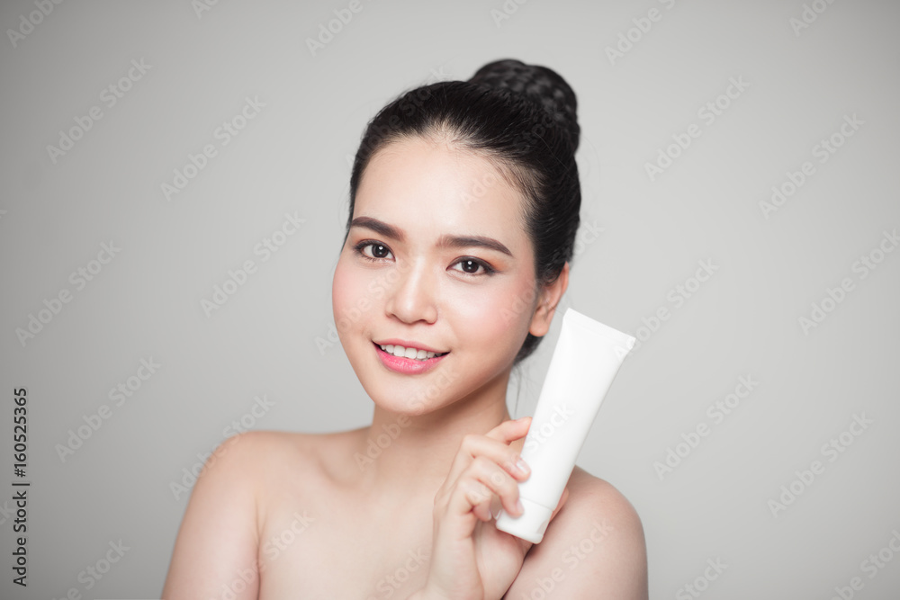 Beauty concept. Asian pretty woman with perfect skin holding cosmetic bottle