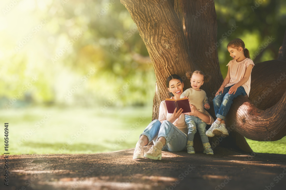 mom reading a book to her children