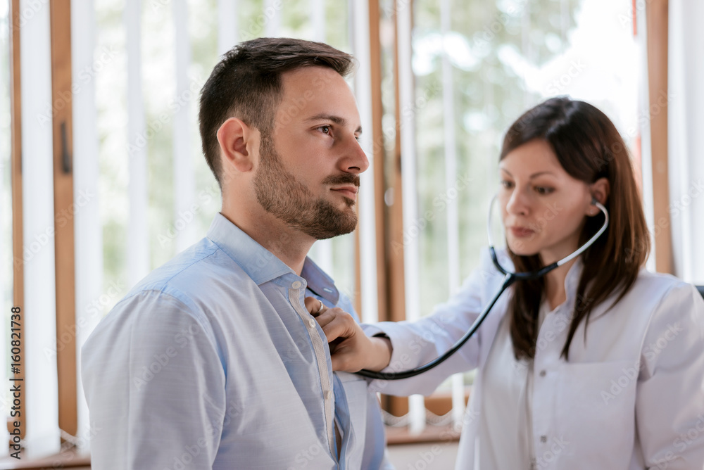 Portrait of confident practitioner checking heart beat of patient