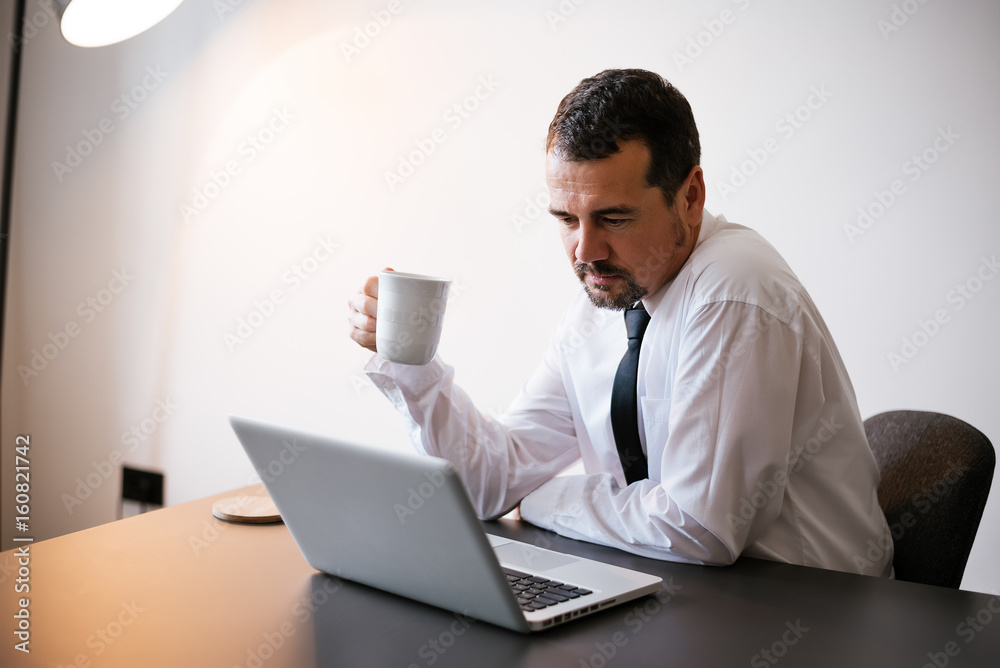 Senior businessman using laptop computer at work