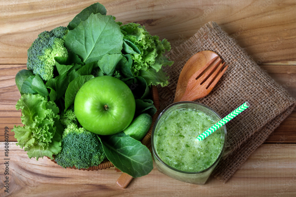 close up green apple with mixed green vegetable and green juice in a basket and wooden fork and spoo