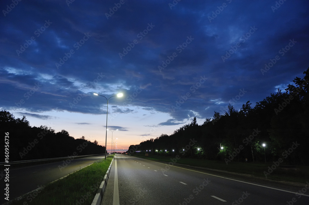 Road lanterns on pillars in the evening against the sky