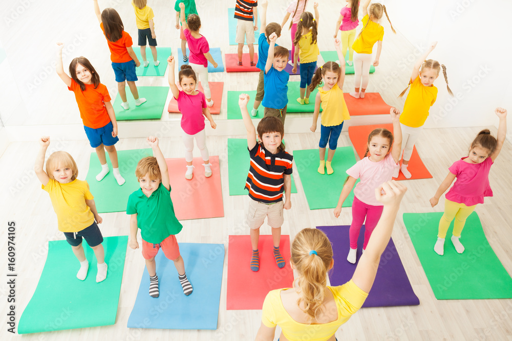 Warming-up during gymnastic lesson for kids in gym