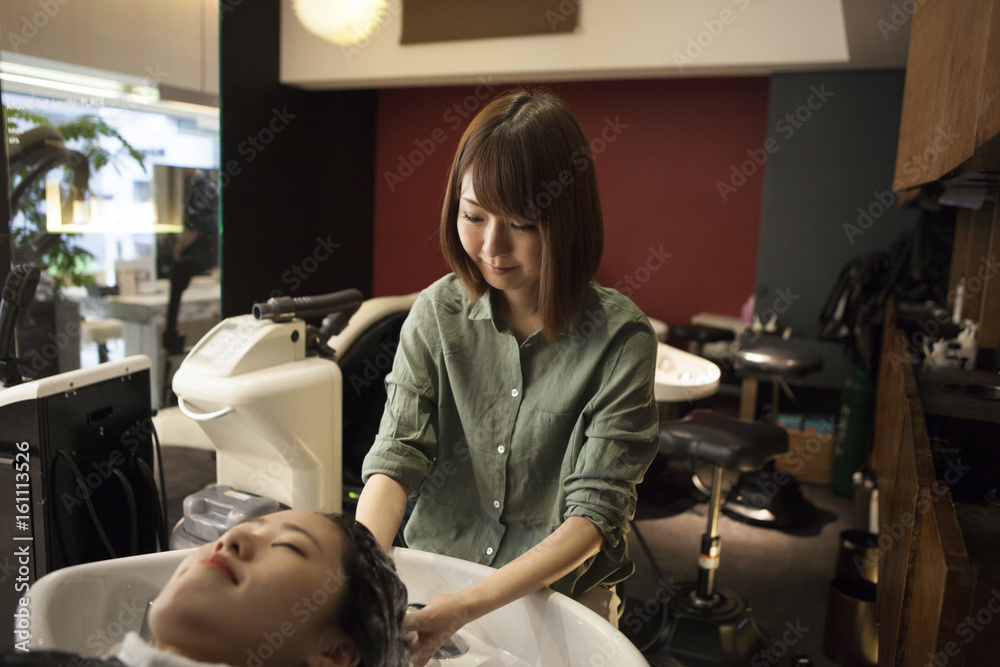 Hairdresser is shampooing female hair