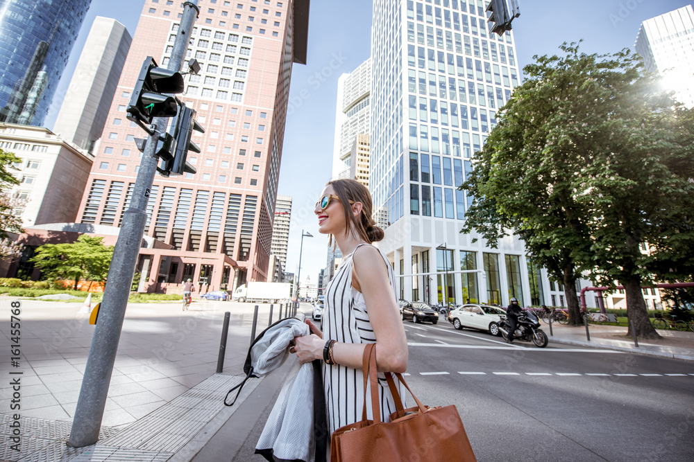 Businesswoman dressed casual crossing the street in the modern district in Frankfurt city