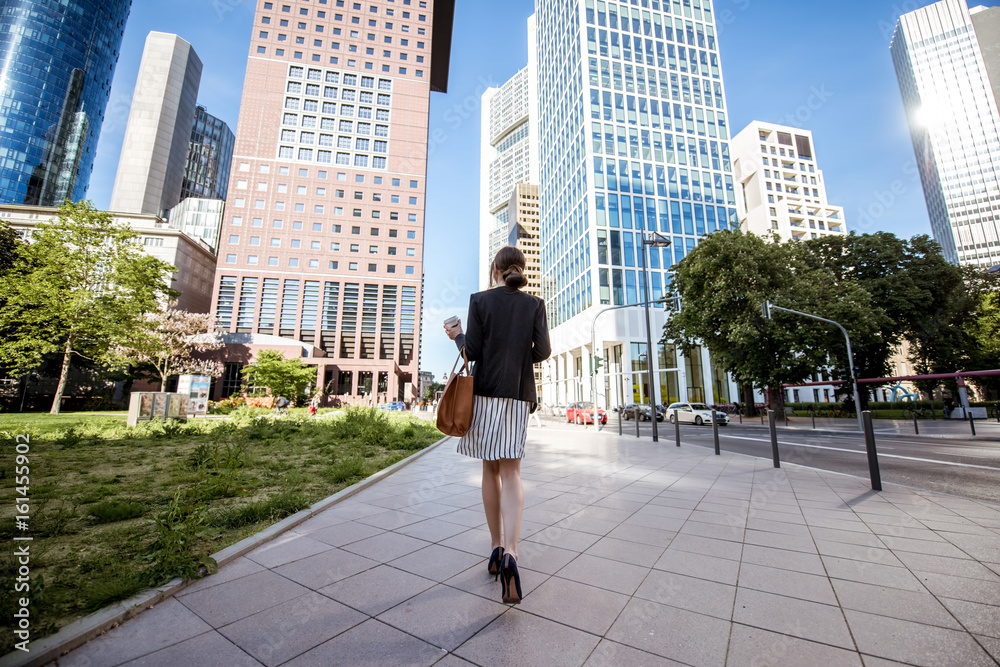 View on the skyscrapers with businesswoman walking back in the modern district in Frankfurt city