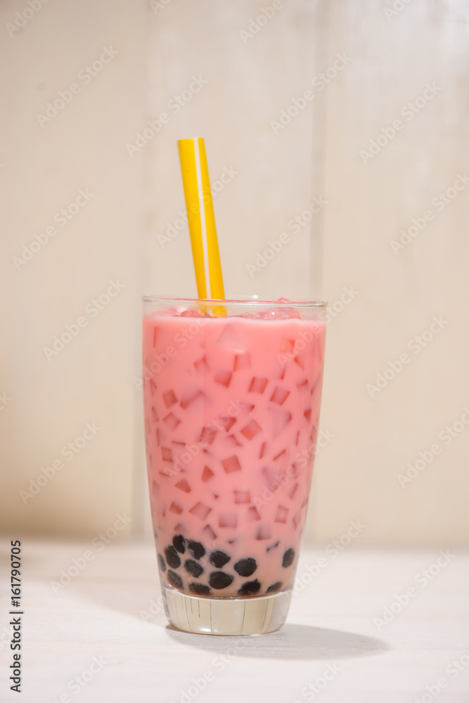 Boba / Bubble tea. Homemade Strawberry Milk Tea with Pearls on wooden table.