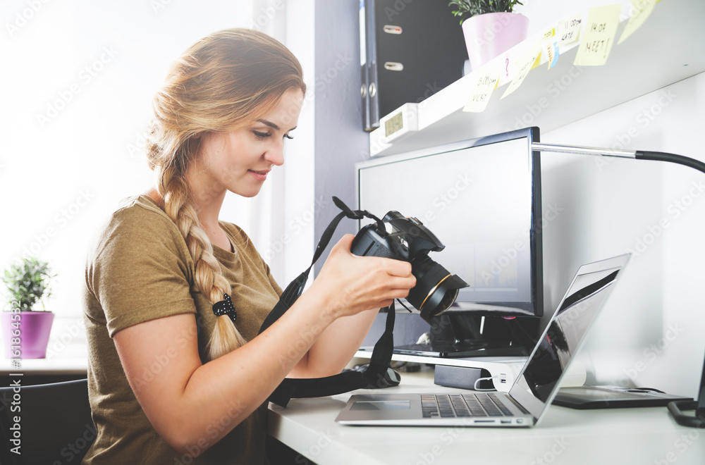 Freelance photographer woman with camera at home office editing photos