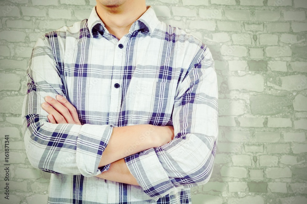 Composite image of mid section of man with arms crossed