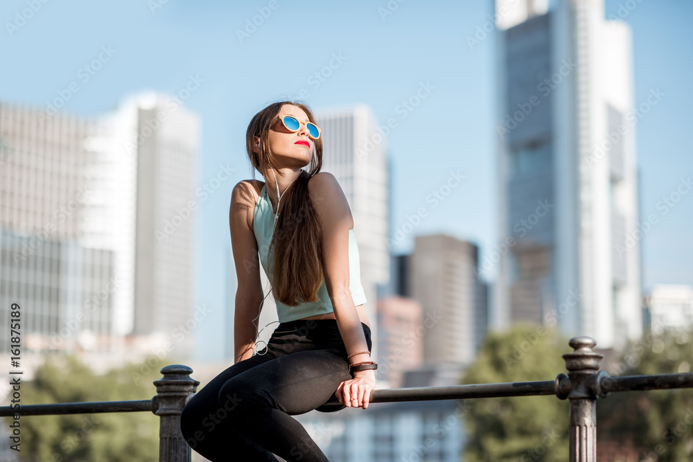 Young woman in sportswear resting on the fence during the morning exercise in Frankfurt city