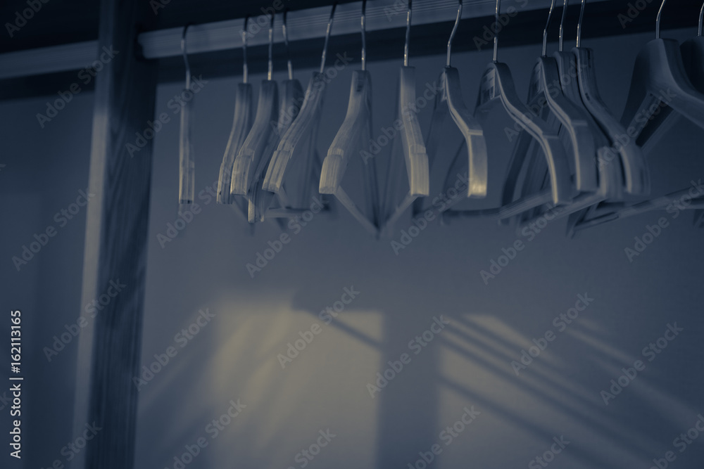 Choice of fashion clothes of different colors on wire hangers